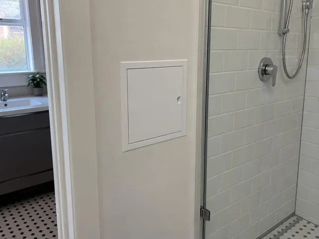 Neat access panel in a bathroom wall beside a tiled shower in Burwood